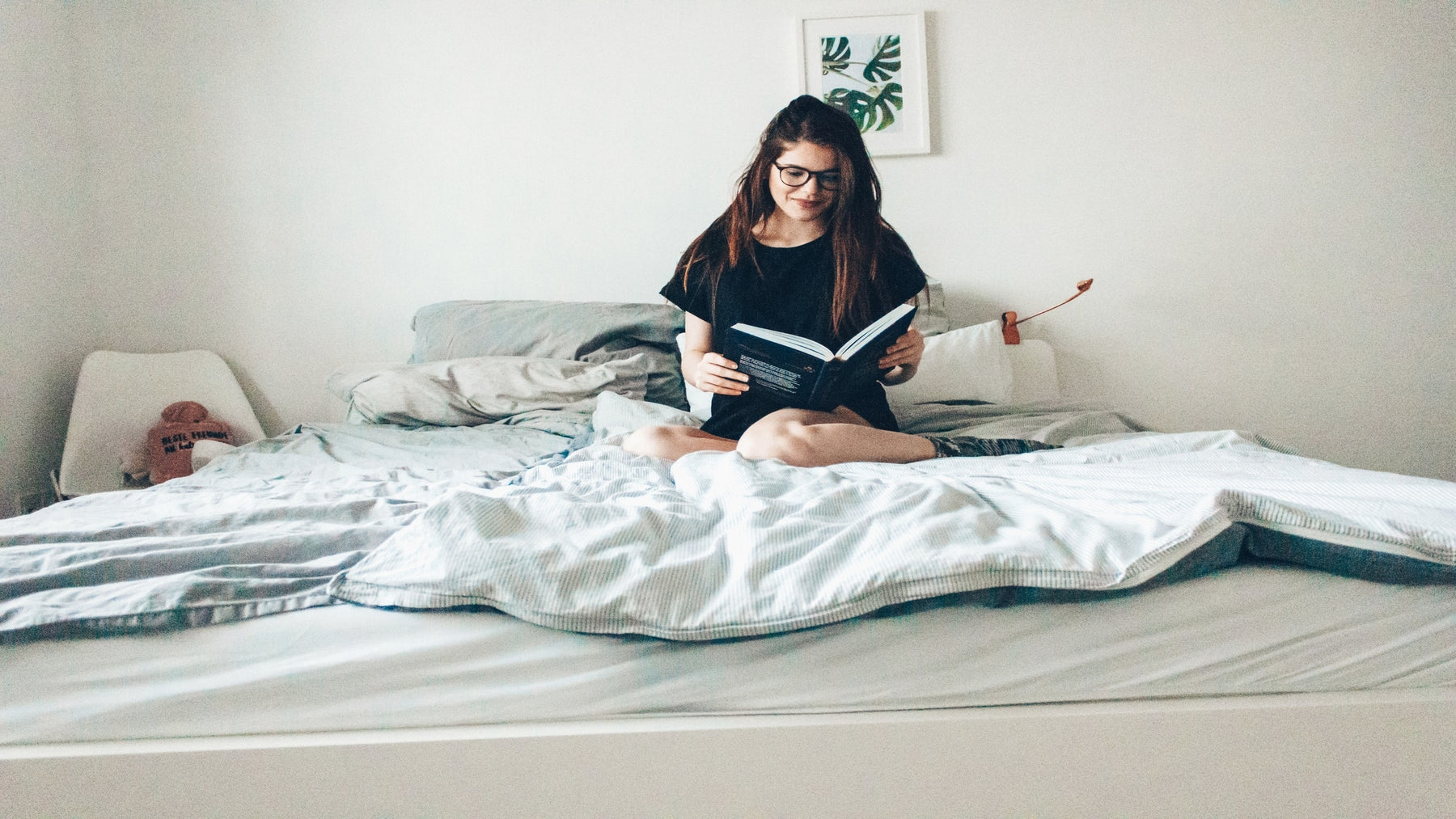 Woman on bed reading a book